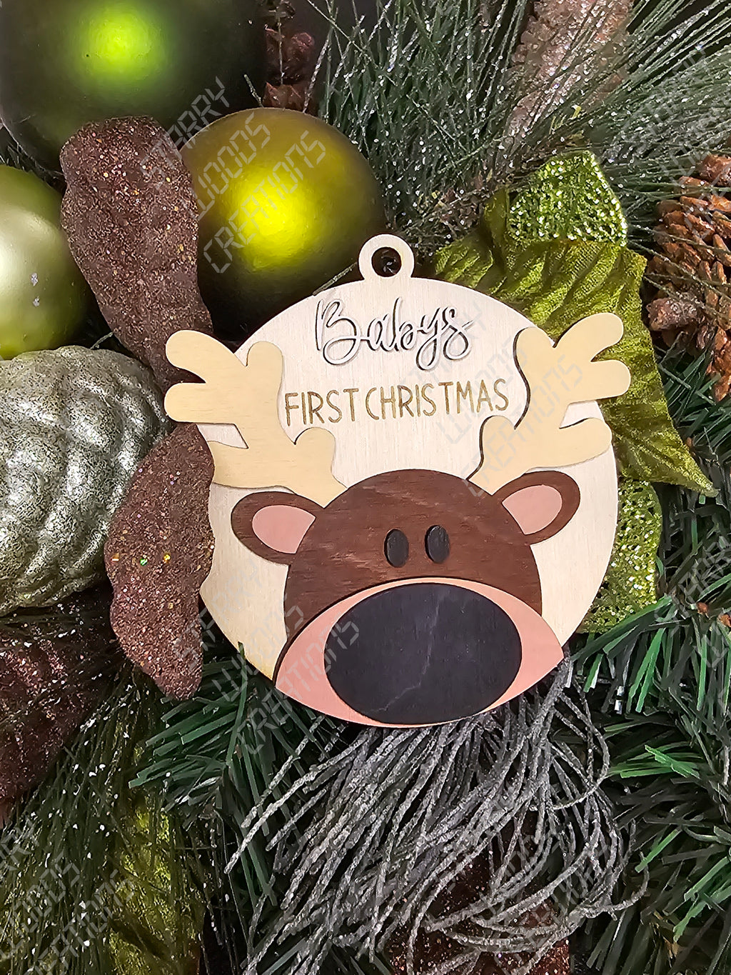 Decorative reindeer ornament with 'First Christmas' text on a Christmas tree. Handmade in Quinte West and customizable.