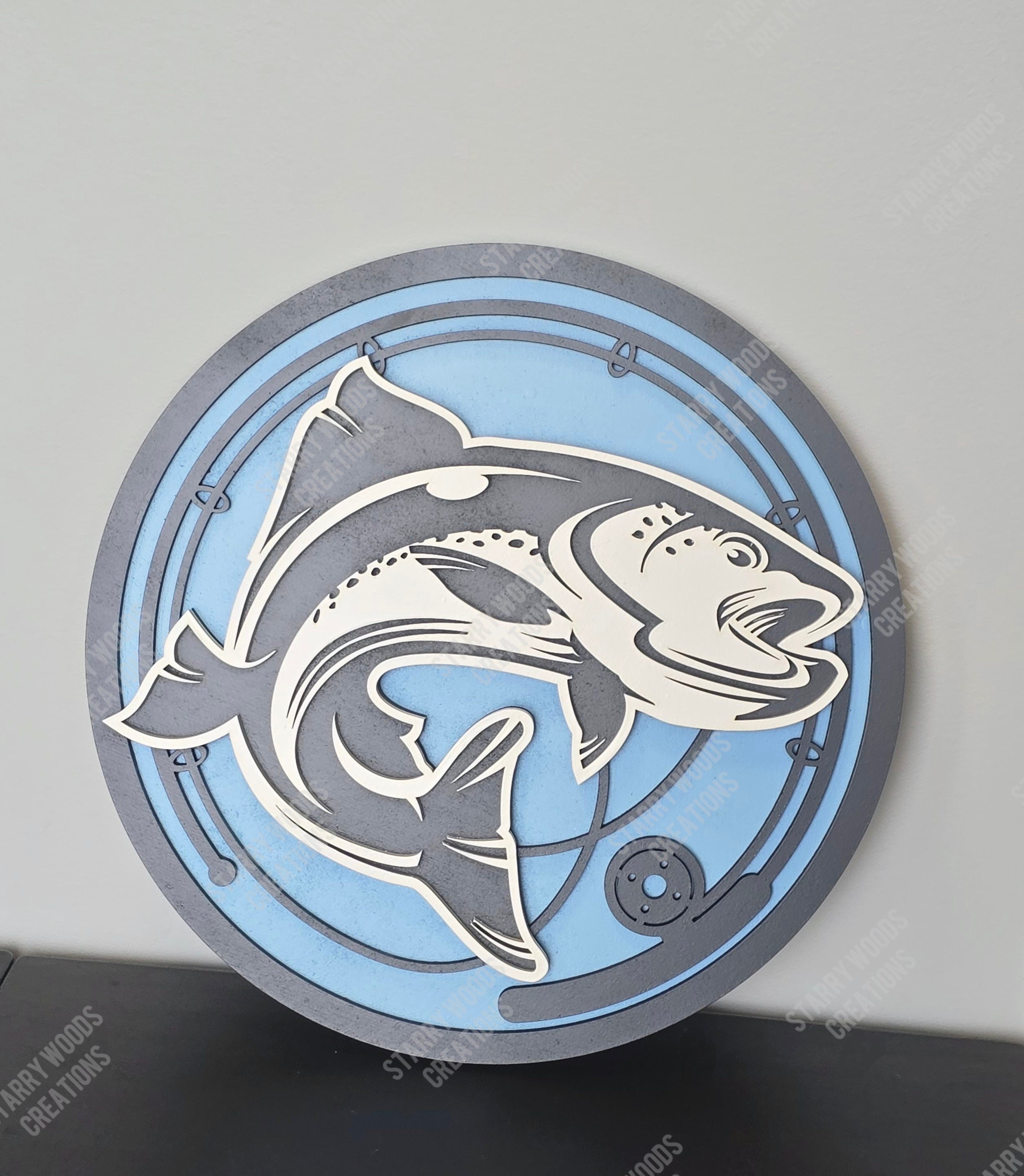Decorative wall art with fish and fishing rod design on a blue and gray background