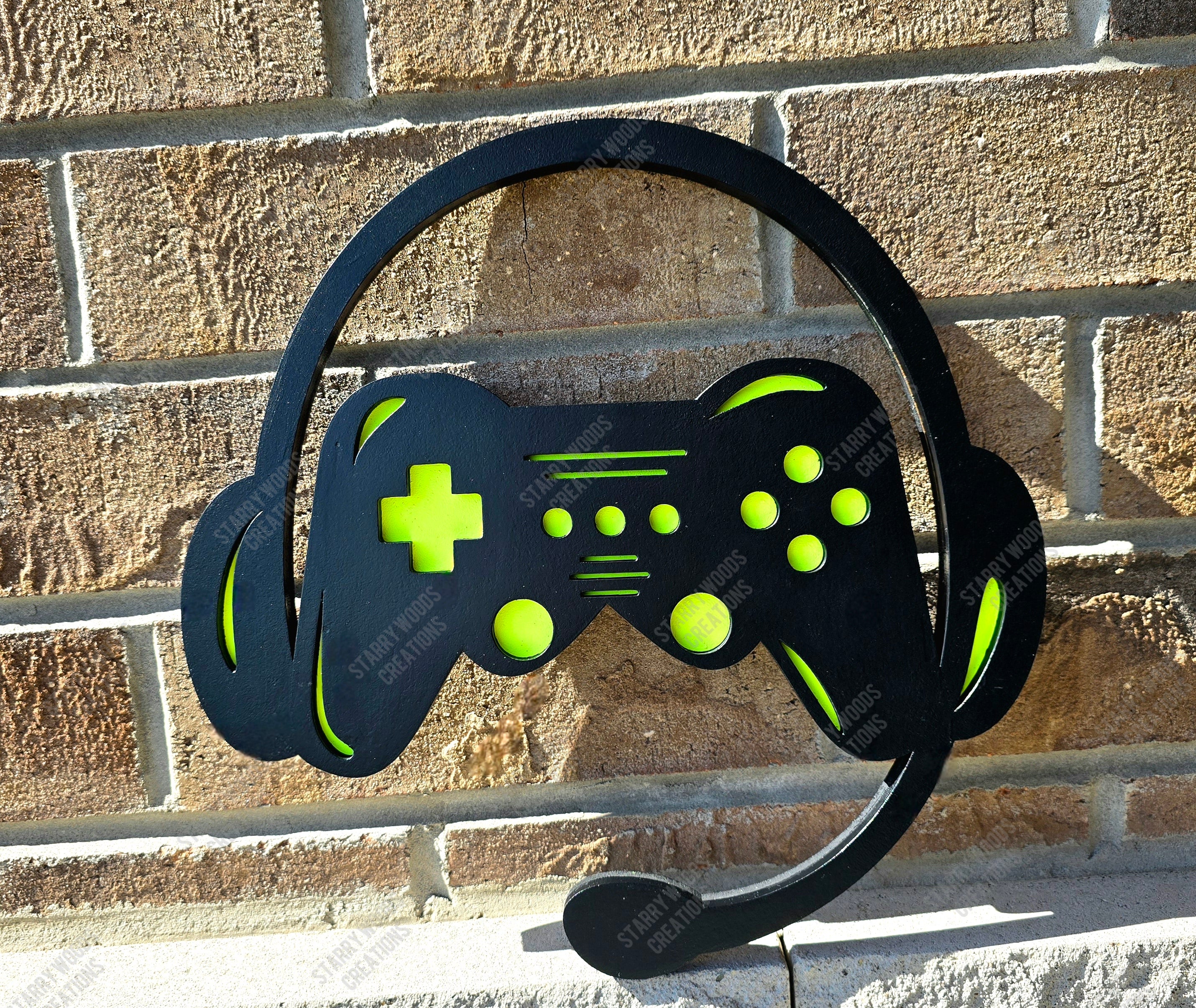 Black and green gaming headset with controller design against a brick wall.