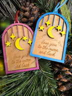 Decorative wooden ornament with moon and star designs on a pine branch background. Customizable gift or decor. Handmade in Ontario.