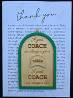 Wooden ornament with engraved text and a 3D coach's cap illustration on a blue background with text.